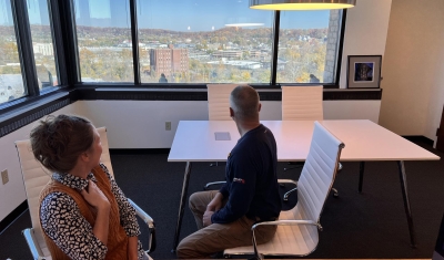 Two Peregrine Falcons perched on the window ledge of 2e Architects in Towson, MD