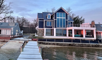 View from the dock to the back of newly constructed home on the Chesapeake Bay for modern coastal designed by 2e Architects